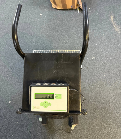 Digital scale with a digital display on a gray floor