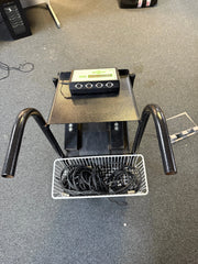 Black electronic device with a basket of cables on a gray floor