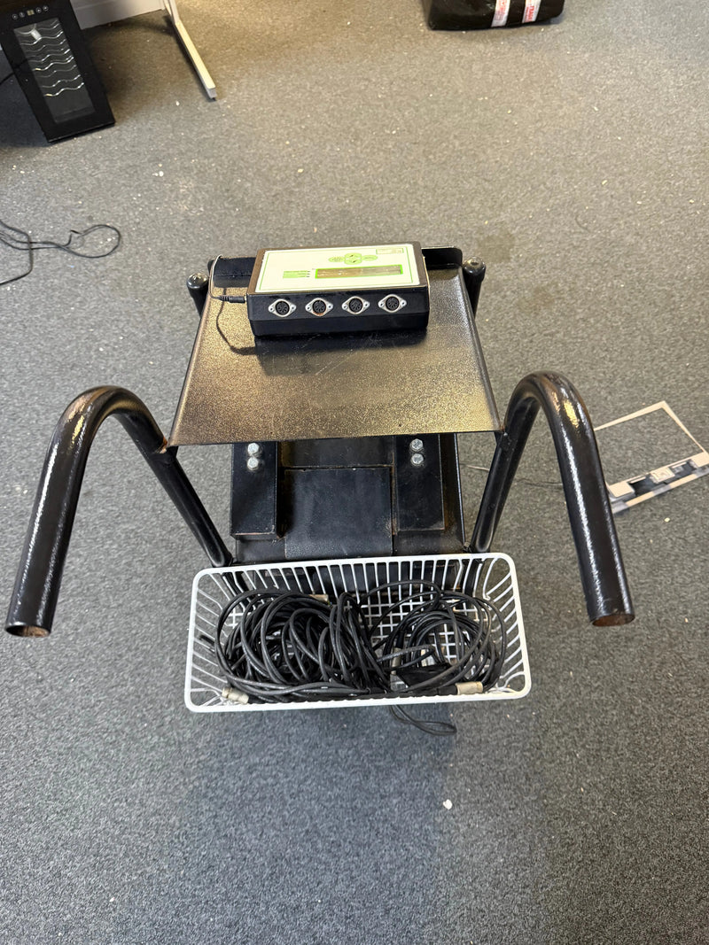 Black electronic device with a basket of cables on a gray floor