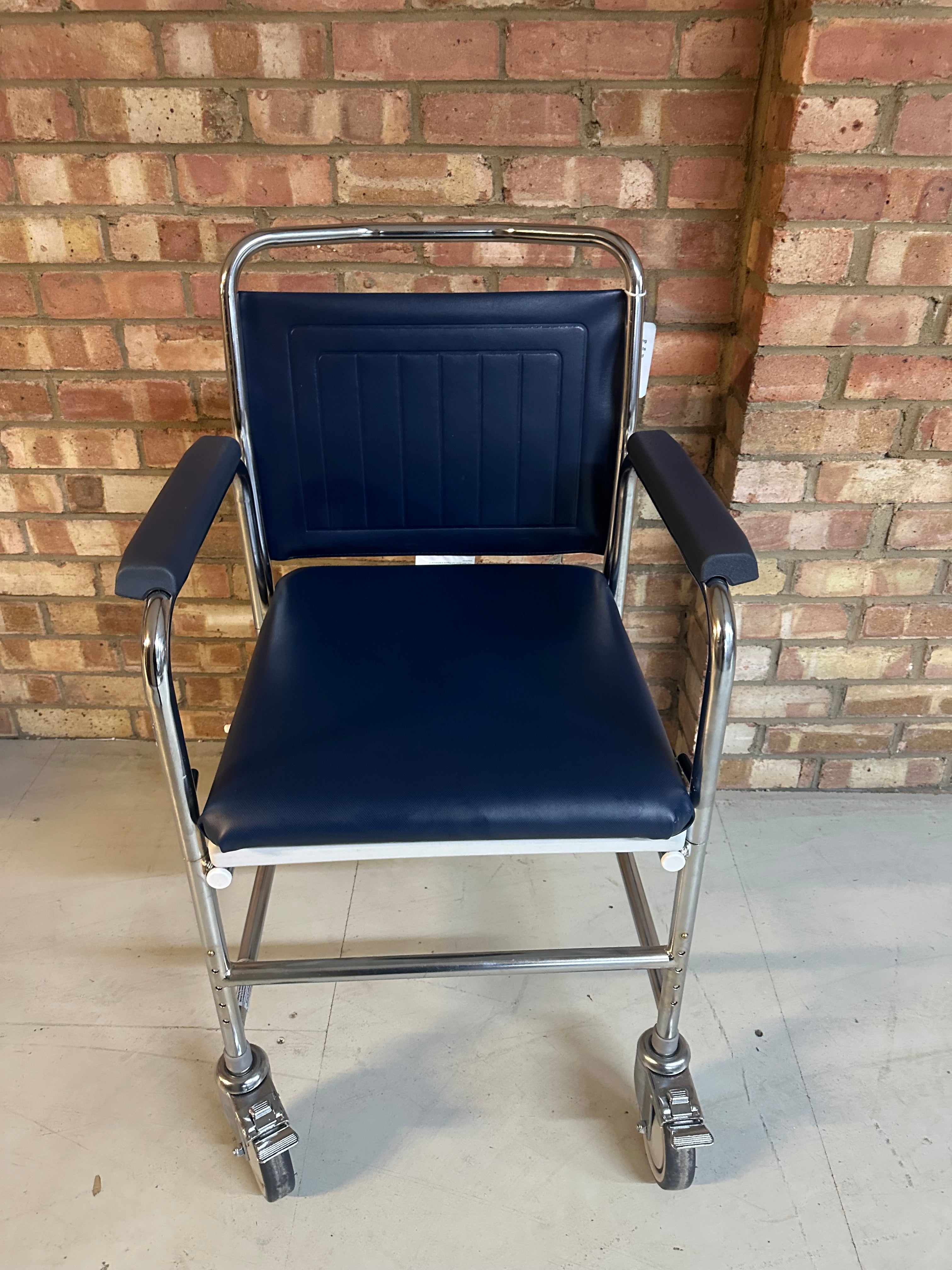 Close-up of the Roma Wheeled Commode featuring height-adjustable legs.