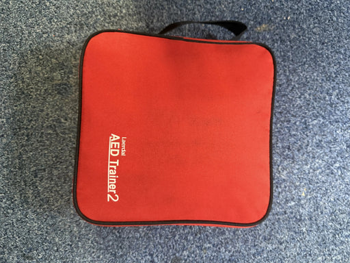 Red AED Trainer 2 case on a gray surface
