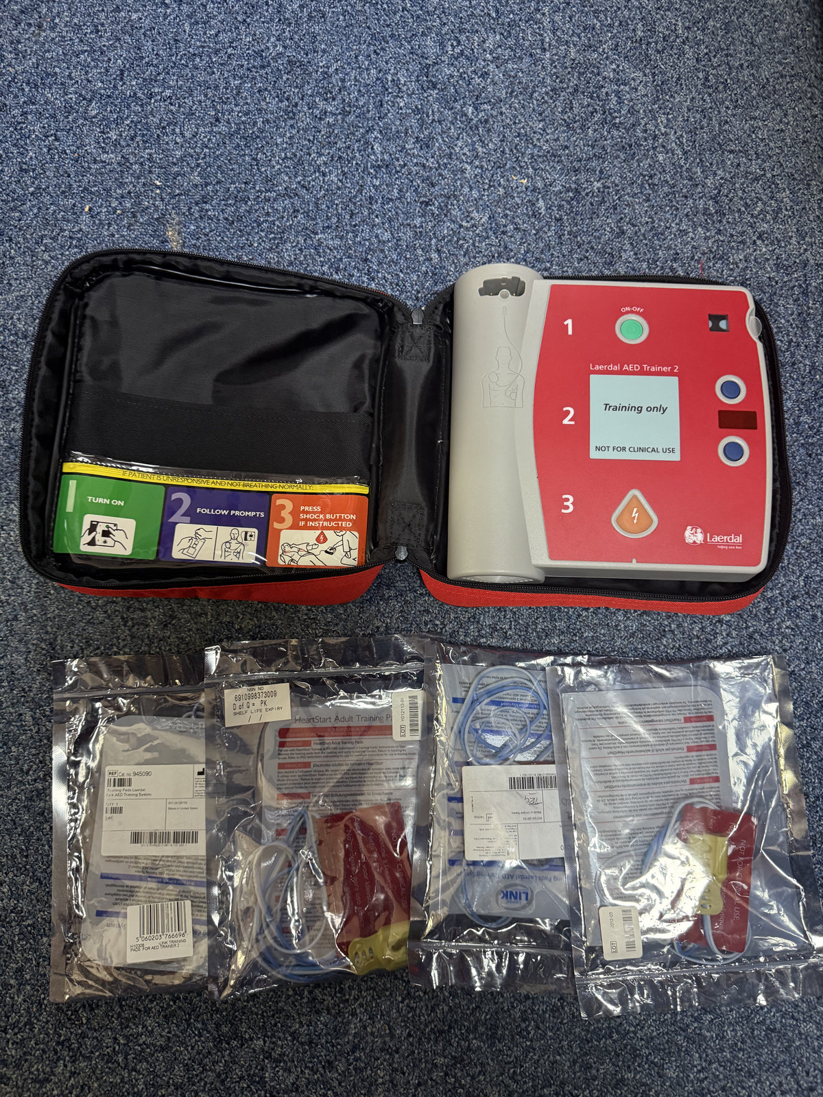 First aid kit with contents on a blue carpet