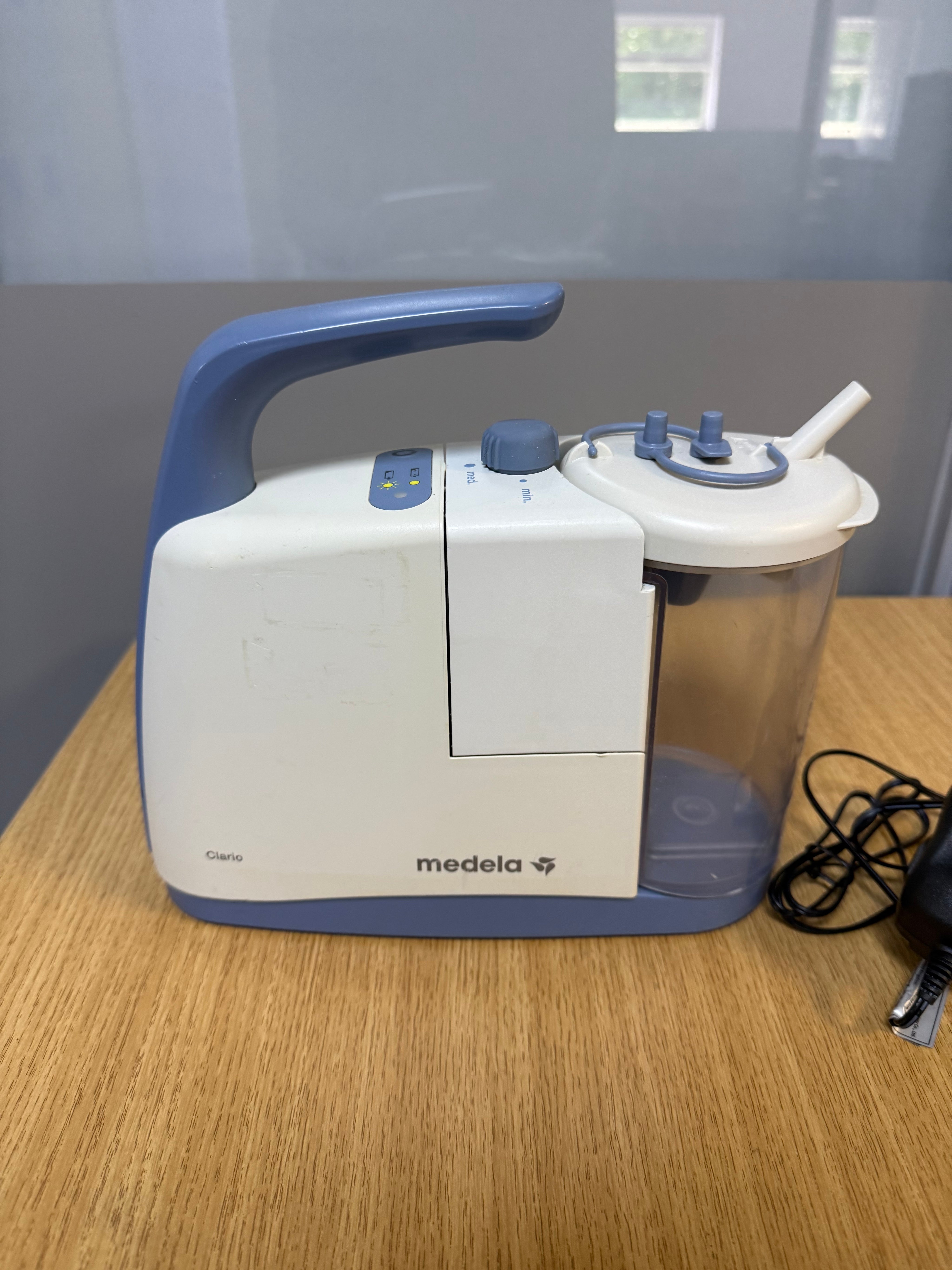 Medela Clario Suction Machine with canister and safety chamber attached