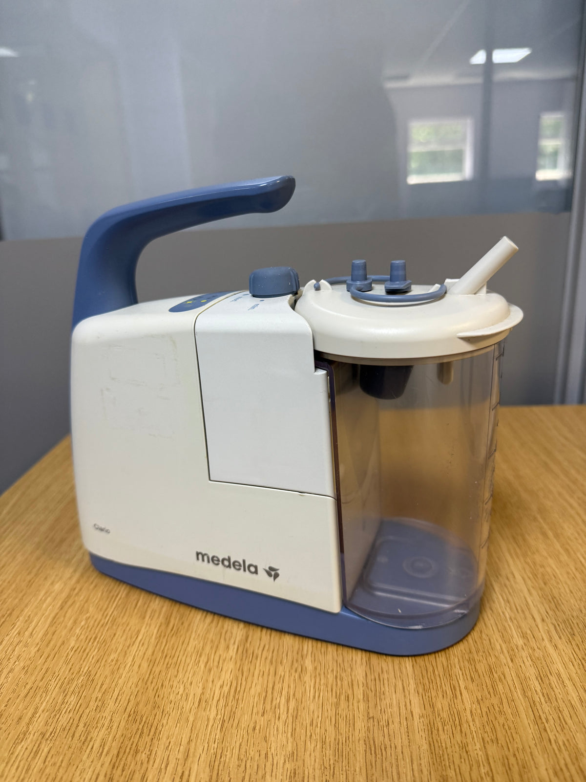 Medela Clario Suction Machine with canister and safety chamber attached