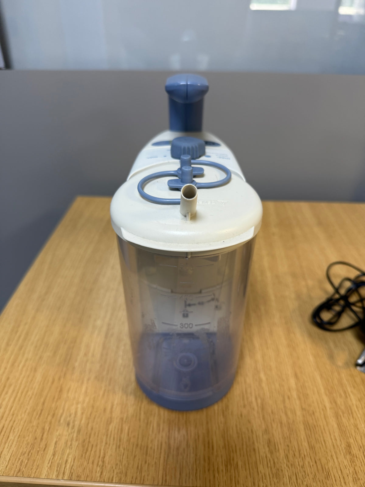 Medela Clario Suction Machine with canister and safety chamber attached