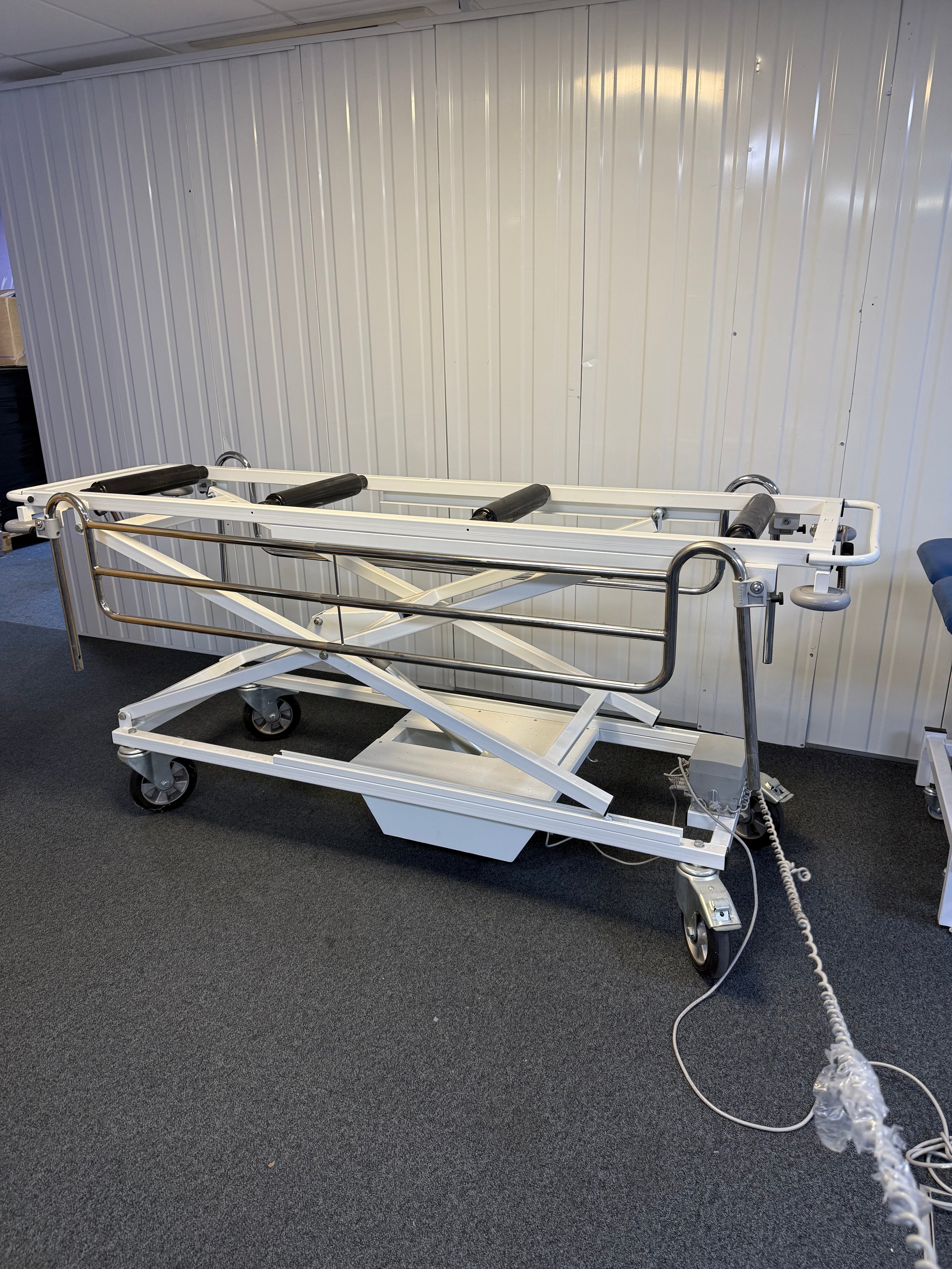 Side view of Electric mortuary table with stainless steel surface and height adjustment controls