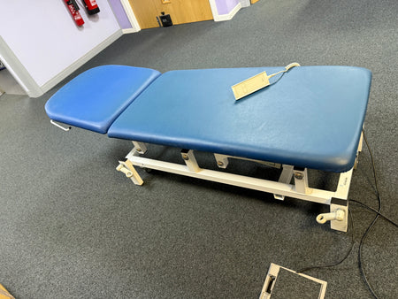 Side view of electric patient couch with adjustable backrest and vinyl upholstery