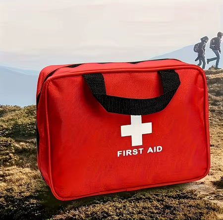 Red first aid kit with a white cross symbol on a natural background