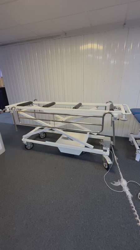 Electric mortuary table with stainless steel surface and height adjustment controls